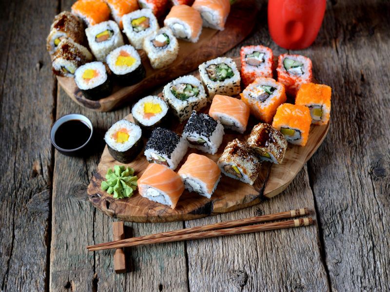 A wooden table with a selection of small sushi pieces