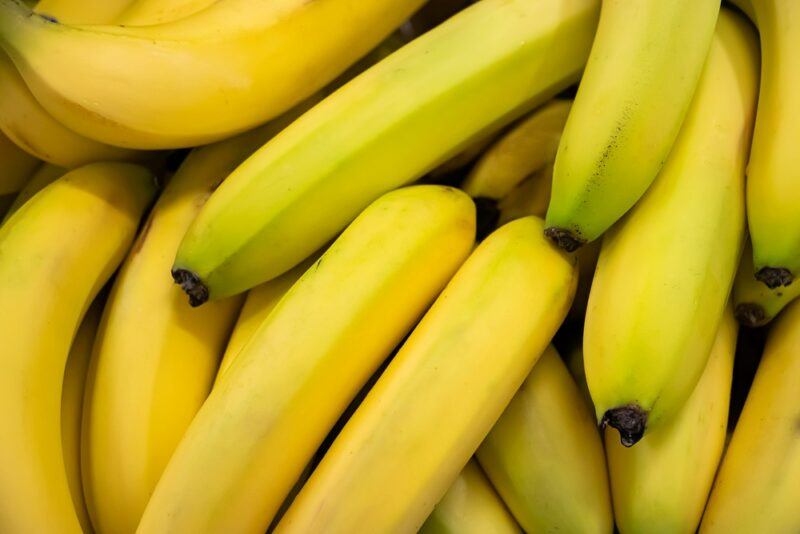 Many fresh yellow bananas in a pile.