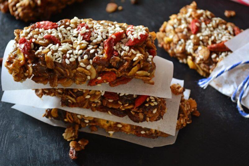 A pile of homemade superfood protein bars, including nuts, seeds, and goji berries