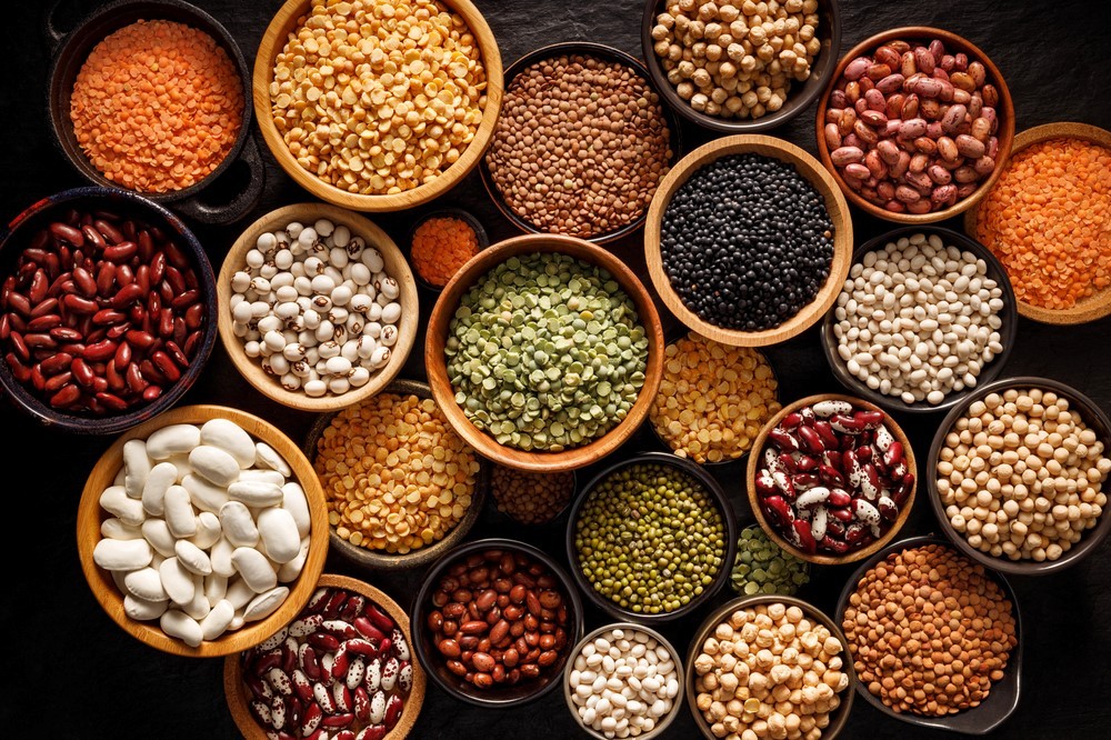 Small bowls filled with legumes, including many types of beans