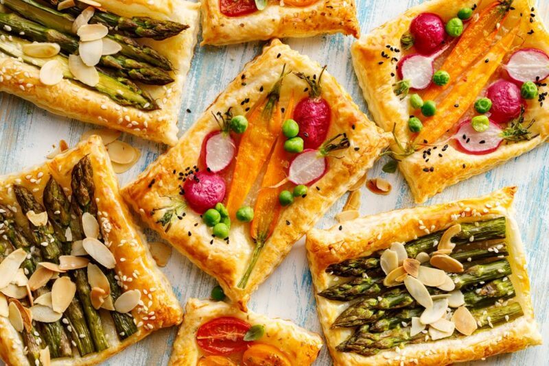 Fresh puff pastry tarts, some with asparagus and others with carrots and radish instead