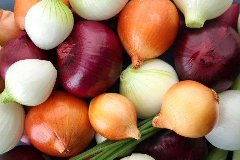 A variety of red, white and brown onions all crammed together