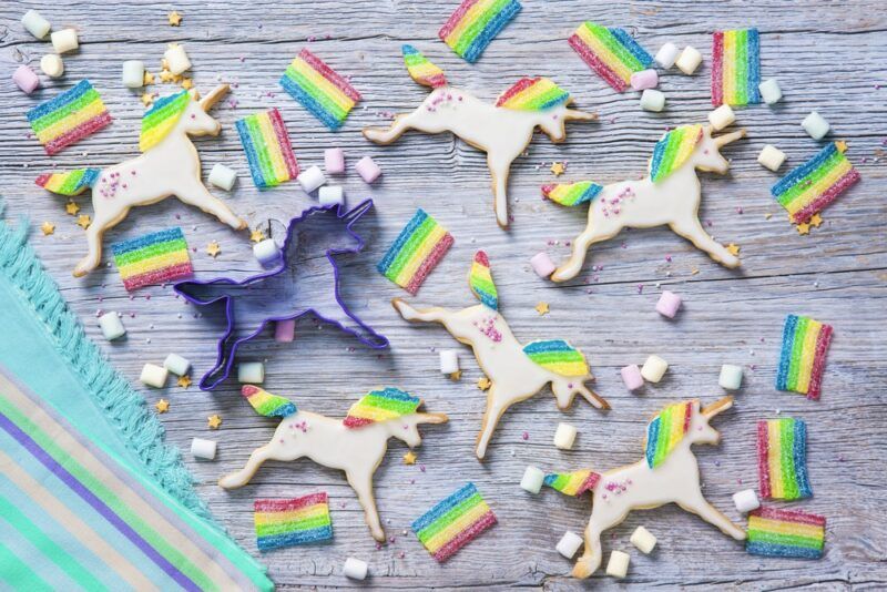 A light gray table with many unicorns, complete with a rainbow mane and tail