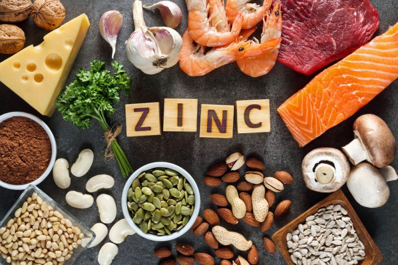 A black wooden table that contains a selection of zinc rich foods