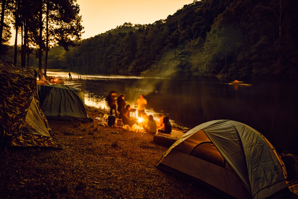 Campers and their tents outside by a river