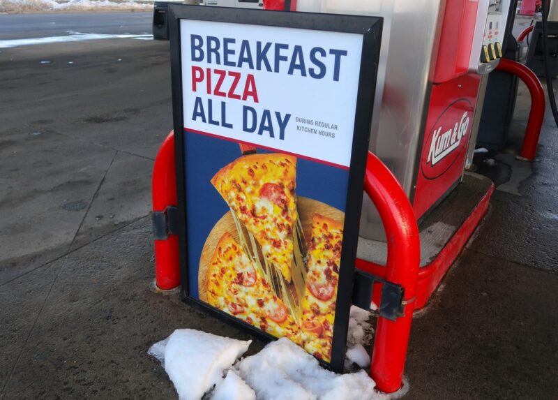 A gas station sign highlighting the idea of breakfast pizza all day