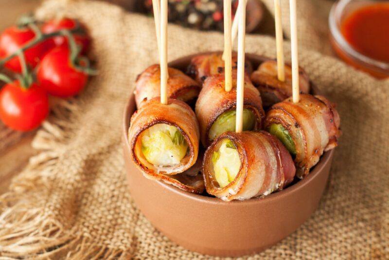 A brown bowl filled with bacon wrapped brussels sprouts