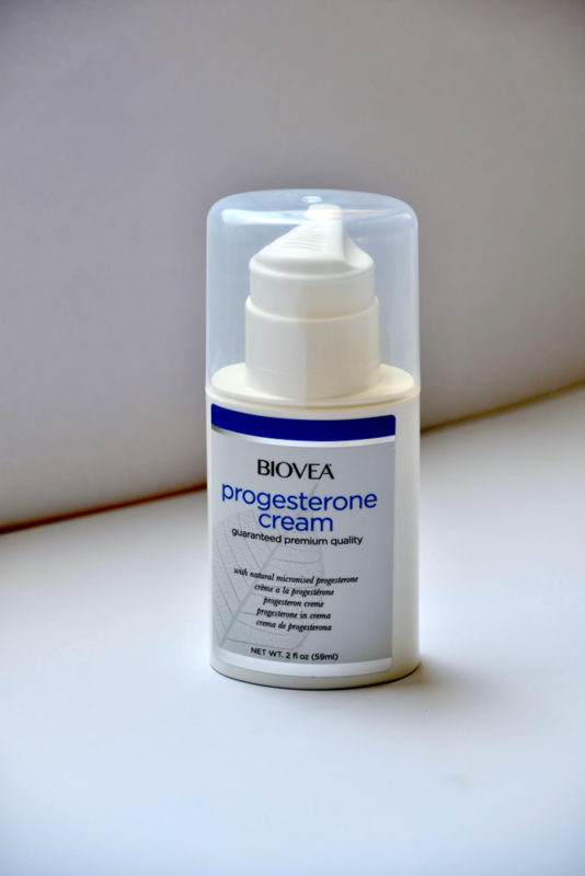 A small bottle of progesterone cream on a white table