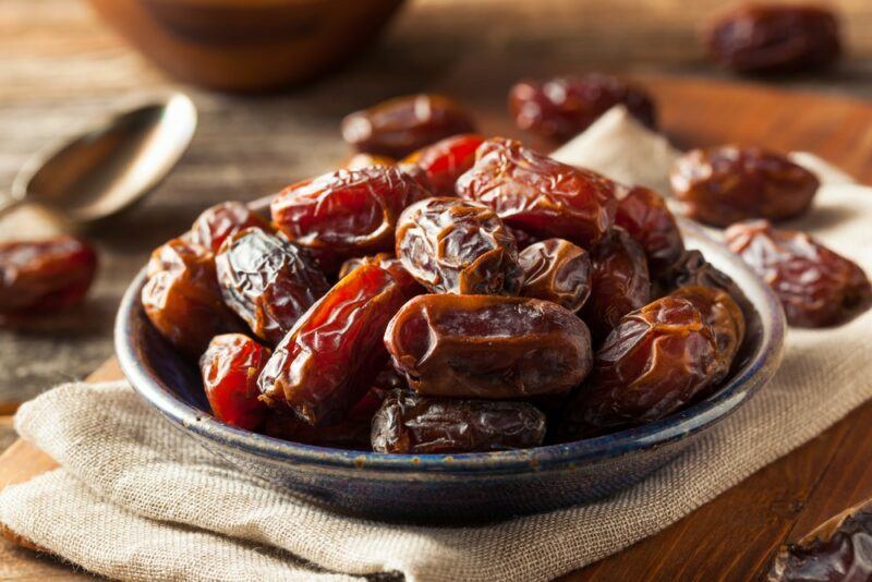 A small dish containing dates on a cloth