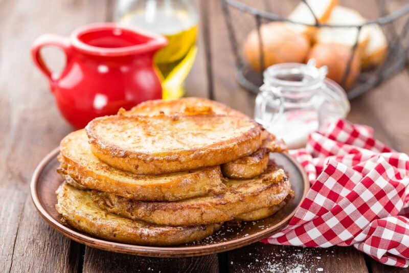 A small plate with a stack of alkaline French toast on a wooden table