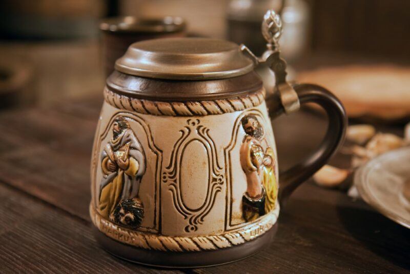 A squat German beer stein with interesting illustrations