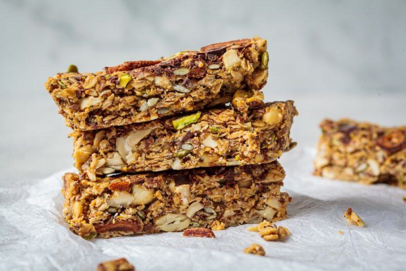 A stack of three homemade plant-based protein bars, with a fourth one in the background