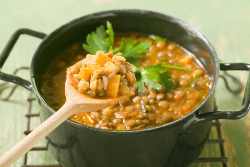 A large black pot containing a lentil stew