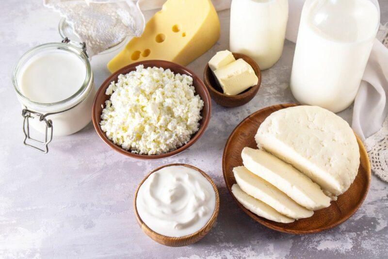 A light colored table with a variety of dairy products, including cheese and sour cream