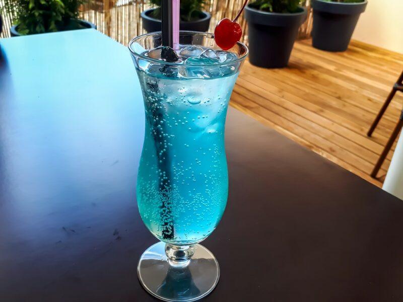 A tall hurricane cocktail containing a sex in the driveway cocktail