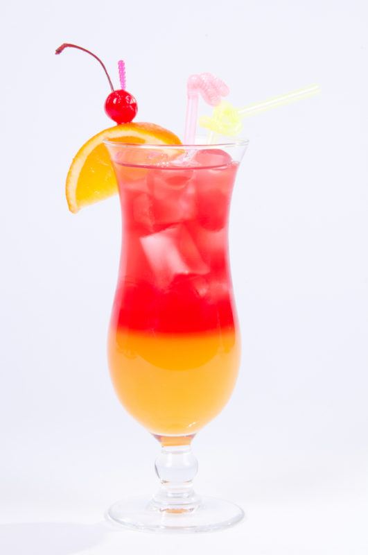 A tequila sunset cocktail in a tall glass isolated on white