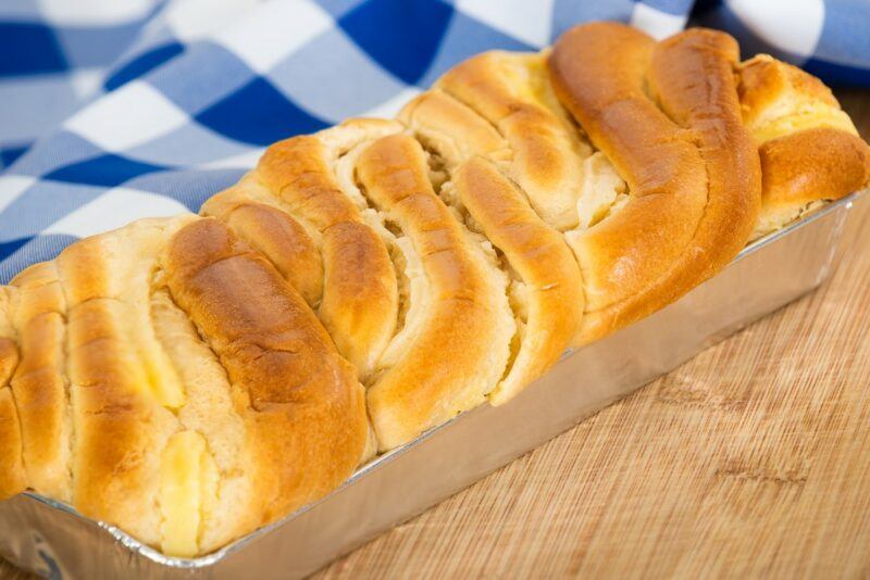 A metal tray with a freshly baked loaf of brioche