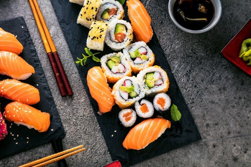 A large black plate containing different types of sushi