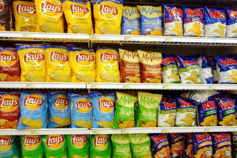 Four shelves in the grocery store, filled with chips