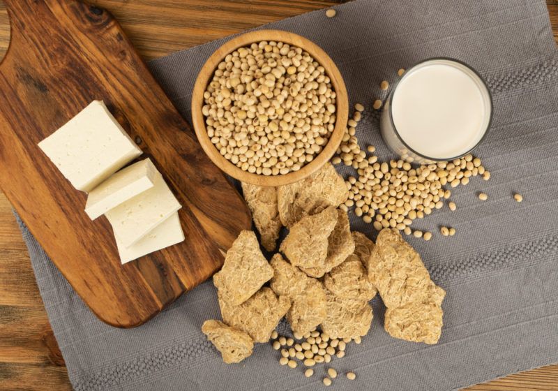 A gray table with various soy products, including tofu and textured vegetable protein