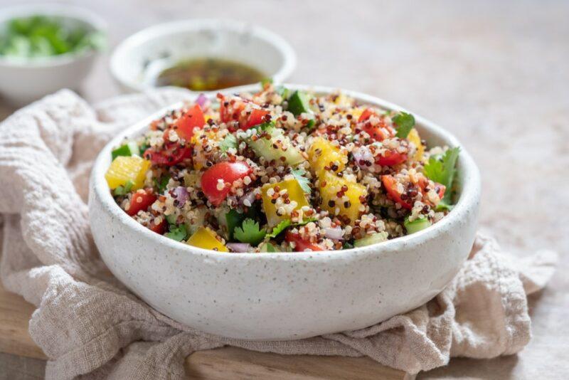 A white bowl containing quinoa salad on a cloth