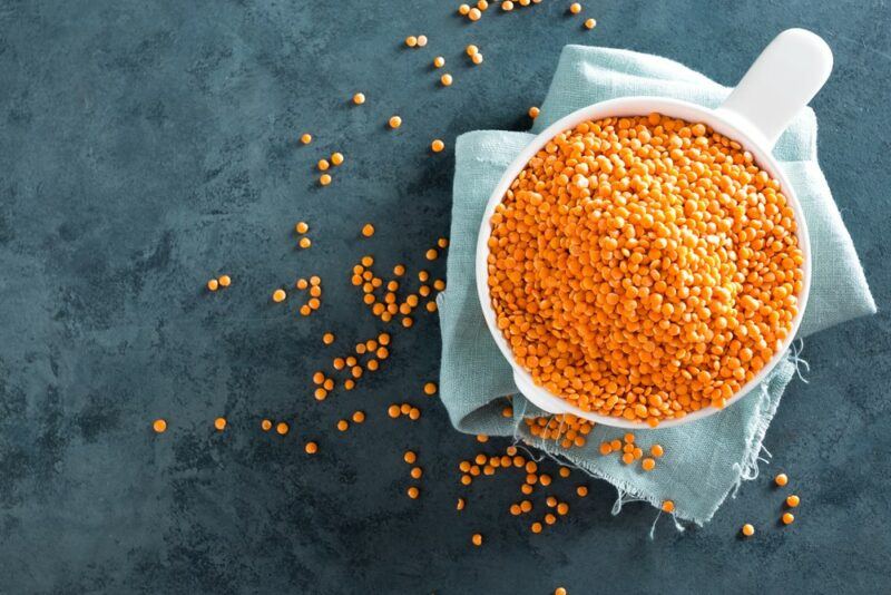 A black table with a bowl filled with red lentils