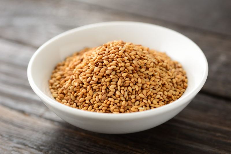 A small white bowl of toasted sesame seeds