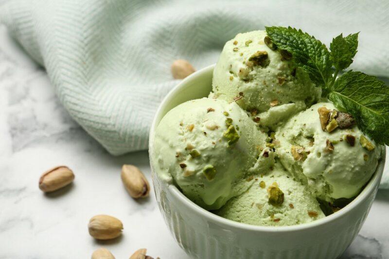 A white bowl with scoops of pistachio ice cream