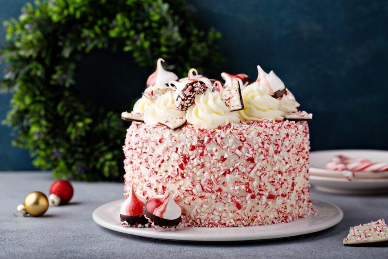 A white chocolate and peppermint cake sitting on a plate outside