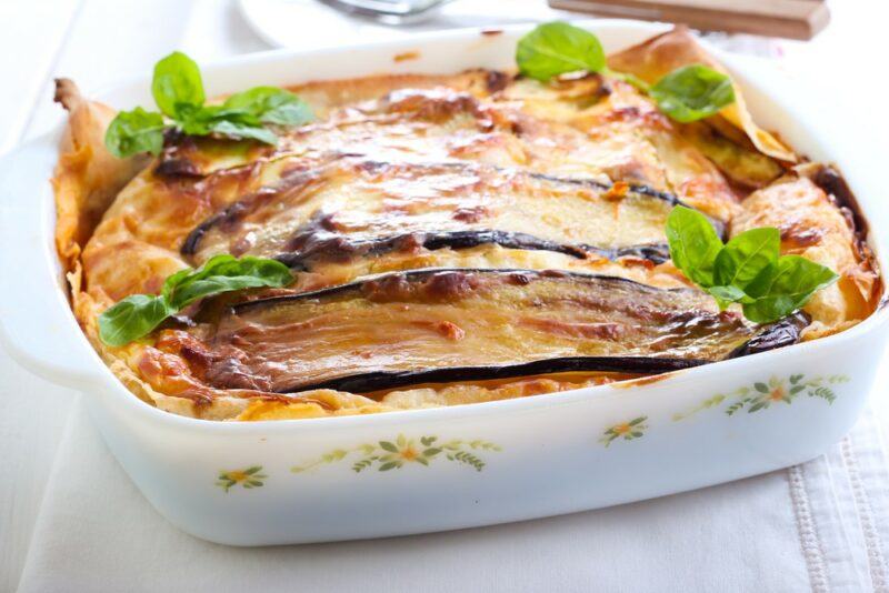 A white dish containing homemade keto lasagna that uses eggplants rather than pasta