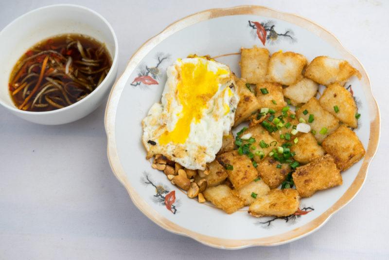 A patterned plate or dish that includes bot chien next to a small bowl of soup