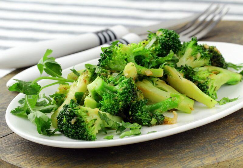 A white dish containing crispy cooked broccoli