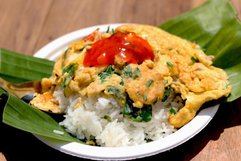 A white bowl with a dish called kai jeow, which is a Thai omelet with rice