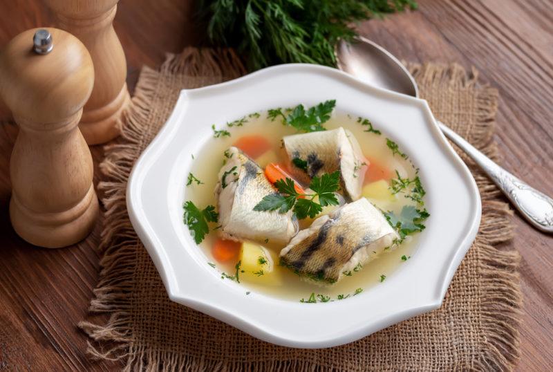 A white dish of ukha on a wooden table