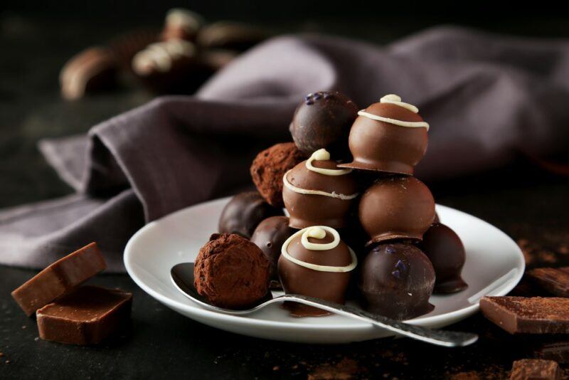 A small white plate containing chocolate truffles