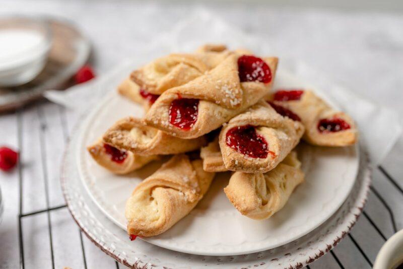 A white plate with cream cheese and berry Kolaczki cookies