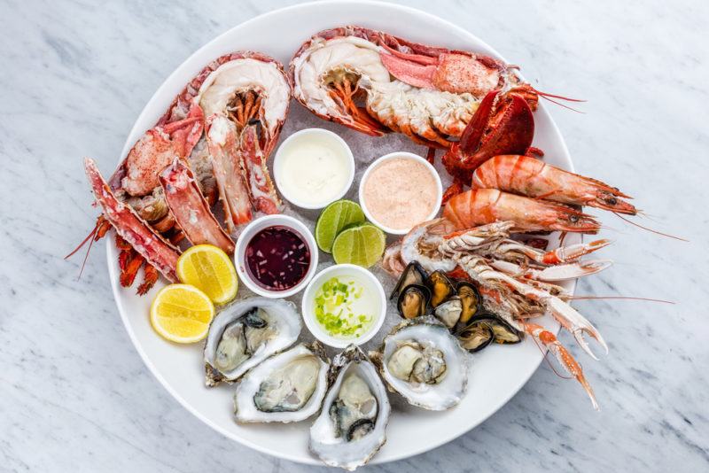 A white dish that contains a selection of different shellfish