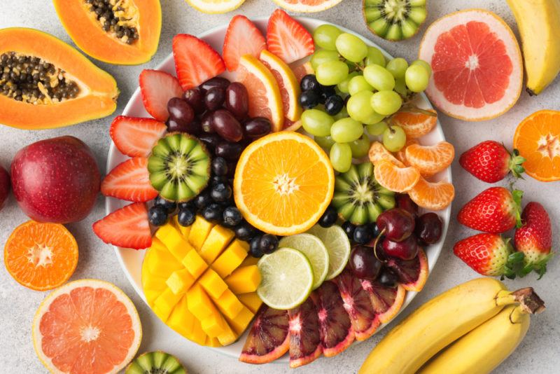 A white plate with a vibrant fruit salad where the fruits have been sliced