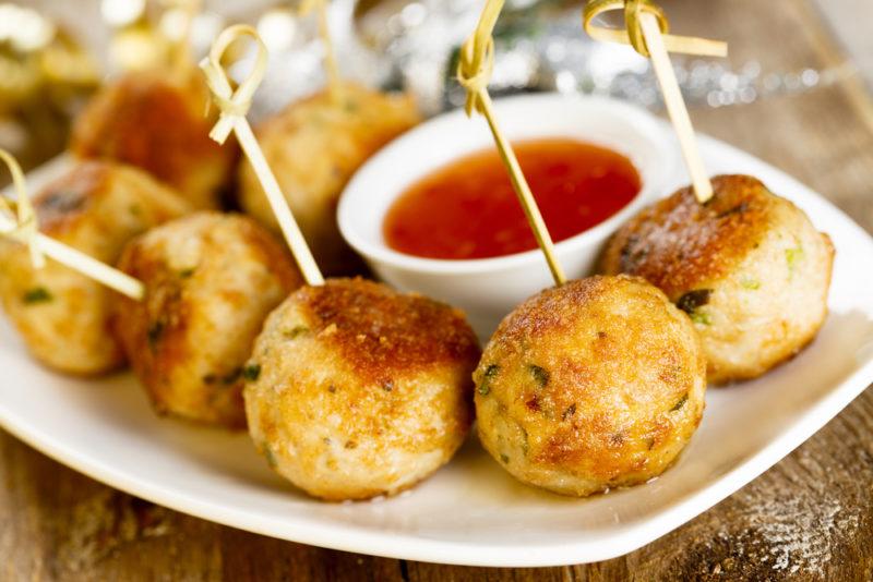 A white plate with meatballs and dip