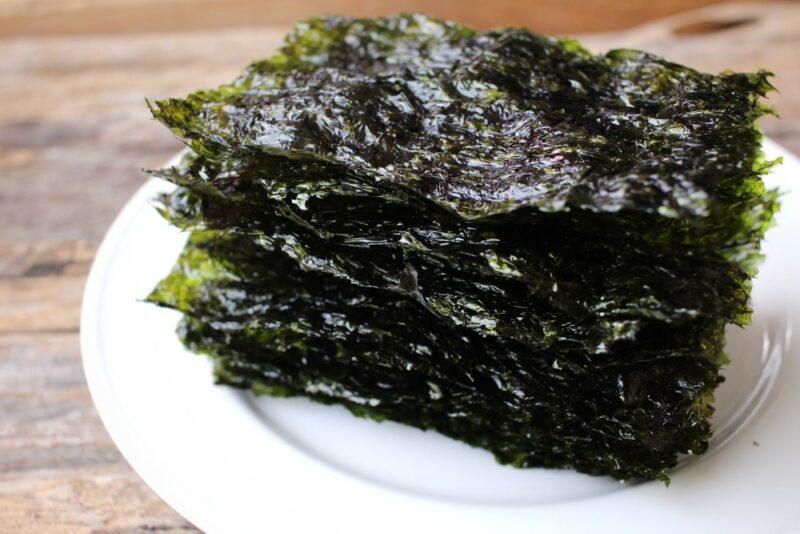 A white plate with a stack of seaweed snacks