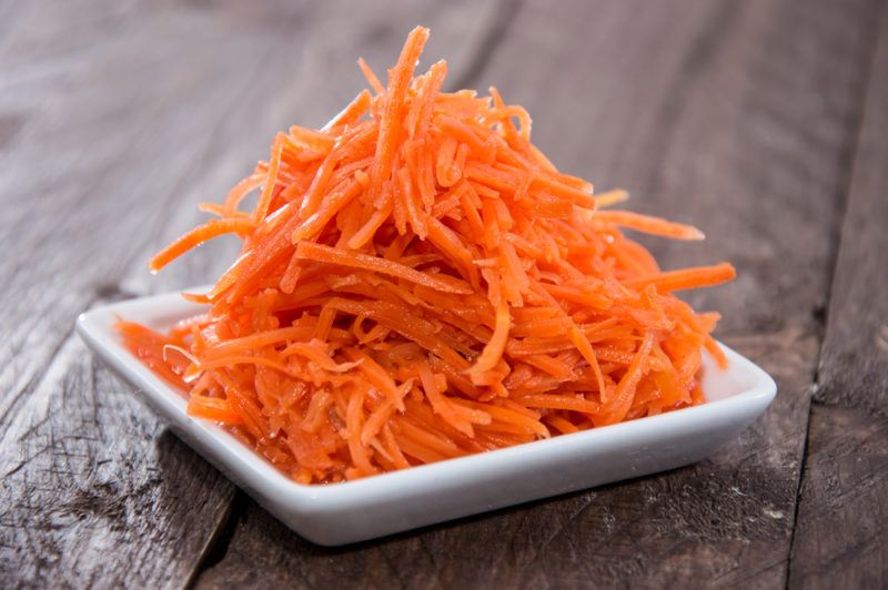 A white bowl of shredded carrots