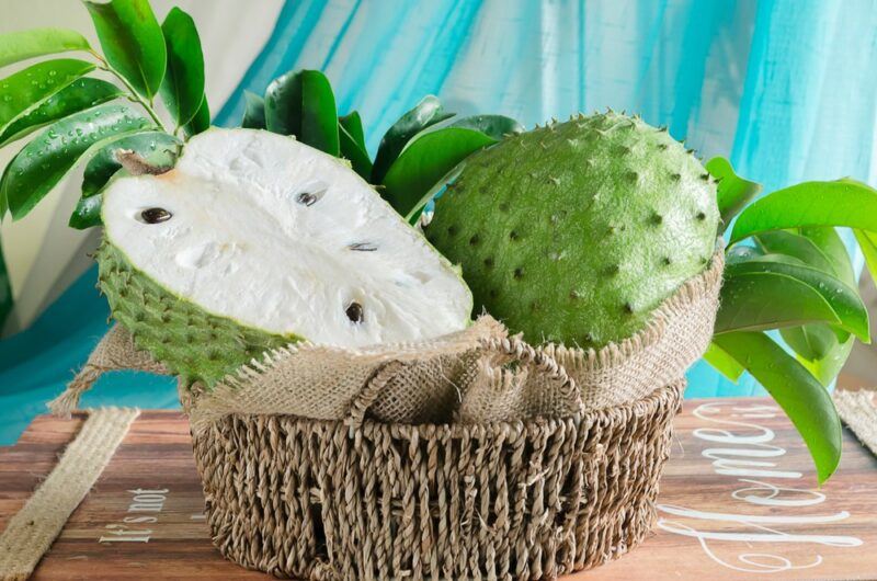 A whole soursop fruit and half of one