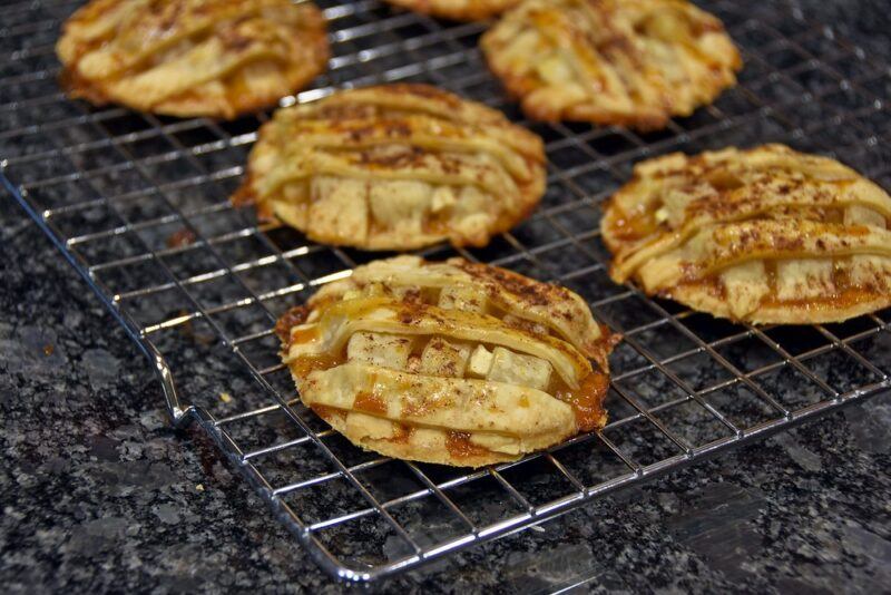 A wire frame with five cookies that look like mini apple pies