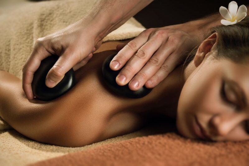 A woman being massaged with hot stones