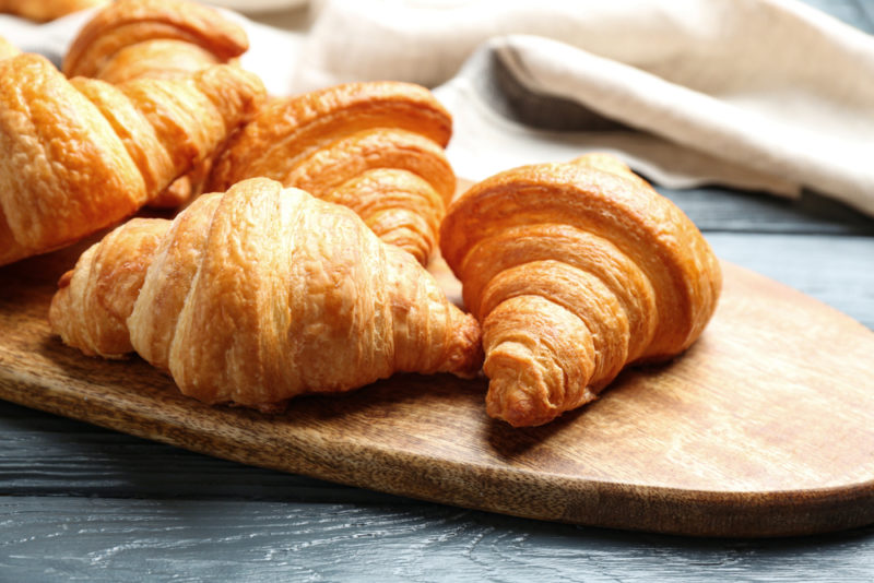 A wooden board with croissants