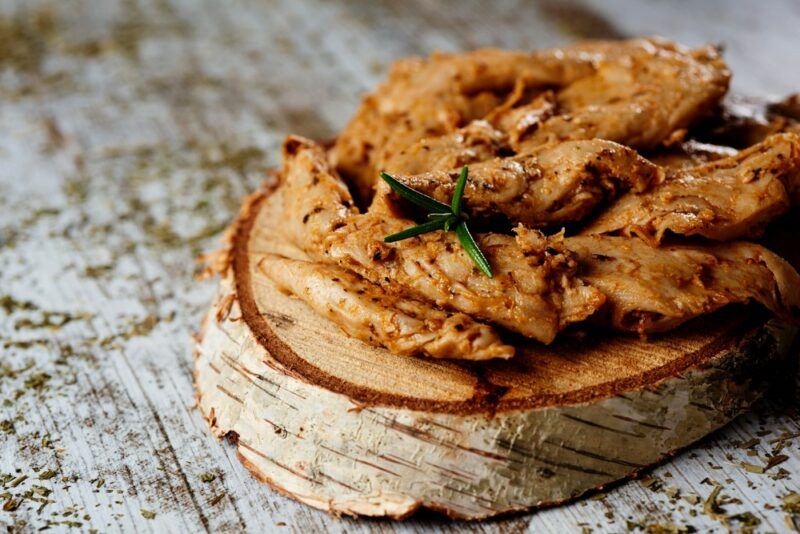 A wooden board with pieces of cooked mock chicken