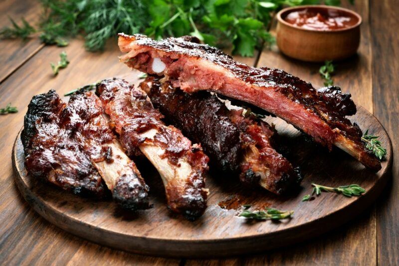 A circular wooden board with cooked pork ribs