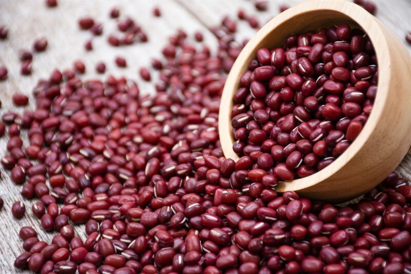 A bowl of red beans spilling out across a table