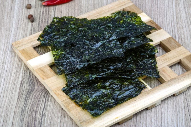 A wooden platform with pieces of dried seaweed ready to be used as a snack