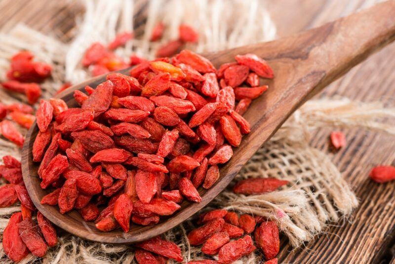 A large spoon filled with dried goji berries